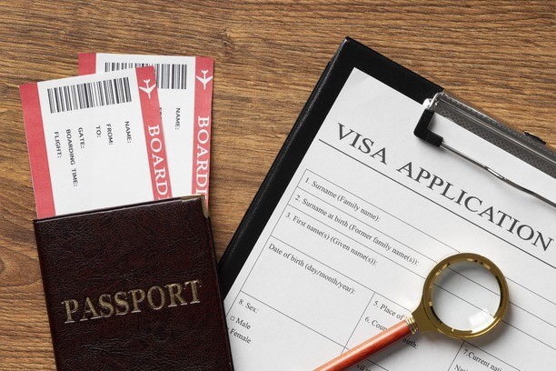 Canada visitor visa application form with a passport and tickets.